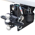 Close-up of a trailer hitch assembly with a shiny ball hitch, black mounting plate, and securing pin ready to connect a trailer