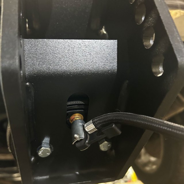 Trail Force air hitch valve below the air spring with an air hose attached