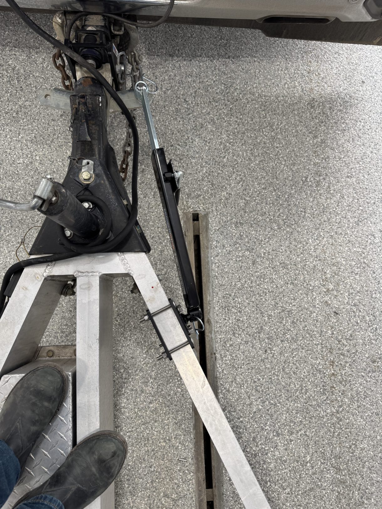 Overhead view of one Shocker sway arm mounted outside an aluminum trailer A-frame rail with an SH-7010 clamp bracket.