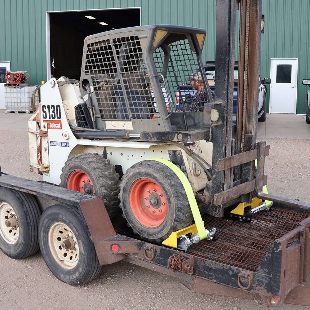Skid Steer Strapped on Trailer